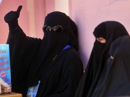 Kuwaiti women, supporters of parliamentary candidate Abdullah al-Azmi, wait outside a poll