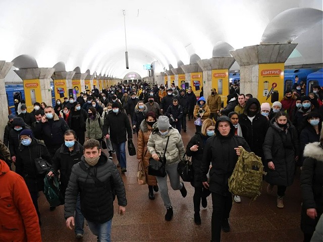 People, some carrying bags and suitcases, walk at a metro station in Kyiv early on February 24, 2022. - Russian President Vladimir Putin announced a military operation in Ukraine on Thursday with explosions heard soon after across the country and its foreign minister warning a "full-scale invasion" was underway. (Photo by Daniel LEAL / AFP) (Photo by DANIEL LEAL/AFP via Getty Images)