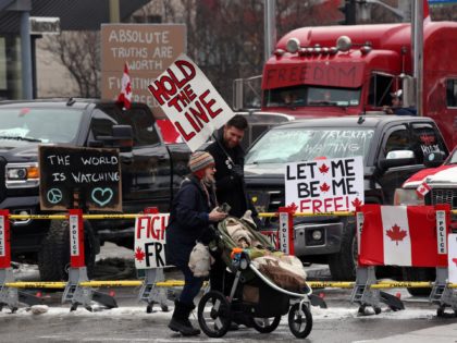 Protesters walks in front of parked trucks as demonstrators continue to protest the vaccine mandates implemented by Prime Minister Justin Trudeau on February 8, 2022 in Ottawa, Canada. (Photo by Dave Chan / AFP) (Photo by DAVE CHAN/AFP via Getty Images)