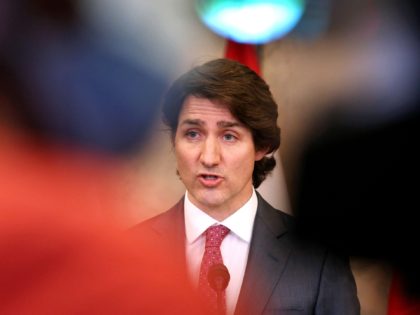 Canada's Prime Minister Justin Trudeau (C) comments on the on going truckers mandate protest during a news conference on Parliament Hill in Ottawa, Canada on February 14, 2022. - Canadian Prime Minister Justin Trudeau on February 14, 2022 invoked rarely-used emergency powers to bring an end to trucker-led protests against …
