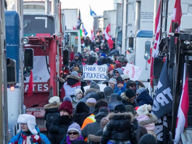 Supporters arrive at Parliament Hill for the Freedom Truck Convoy to protest against Covid-19 vaccine mandates and restrictions in Ottawa, Canada, on January 29, 2022. - Hundreds of truckers drove their giant rigs into the Canadian capital Ottawa on Saturday as part of a self-titled "Freedom Convoy" to protest vaccine …
