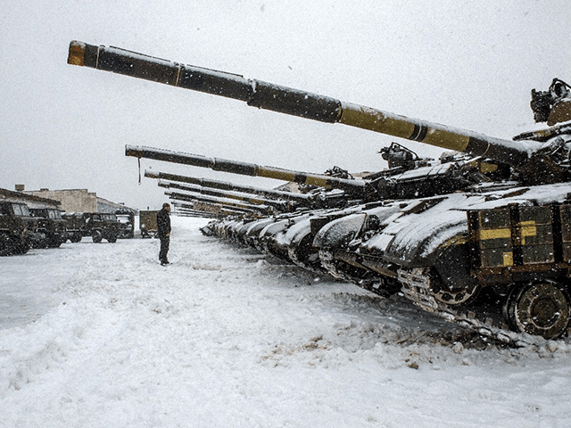 An Ukrainian Military Forces serviceman stands in front of tanks of the 92nd separate mech