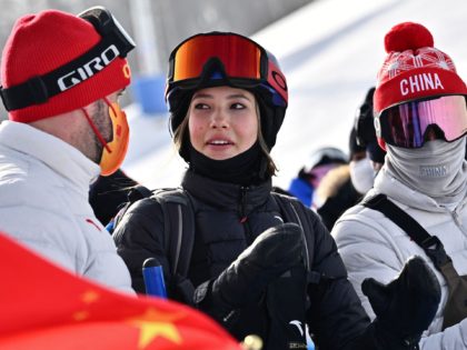 China's Gu Ailing Eileen (C) speaks while watching the snowboard women's halfpipe final ru