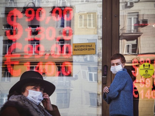 People walk past a currency exchange office in central Moscow on February 28, 2022. - The