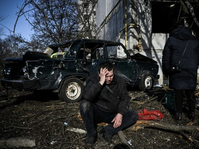 TOPSHOT - A man sits outside his destroyed building after bombings on the eastern Ukraine