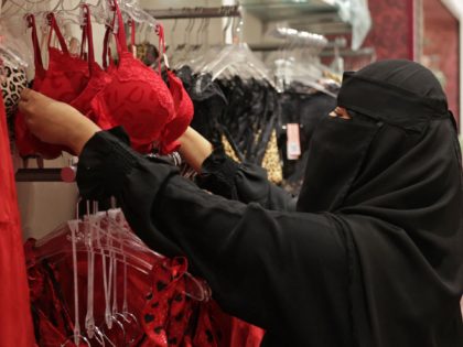 A saleswoman arranges displays in an underwear store decorated for Valentine's day, in Panorama mall in the Saudi capital Riyadh, on February 9, 2022. - Red clothing and underwear are displayed in Saudi shops, but the increasingly popular Valentine's Day promotions are missing one thing: the festival's name. (Photo by …