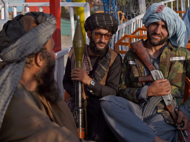 In this photograph taken on September 28, 2021 Taliban fighters enjoy a ride on a pirate s