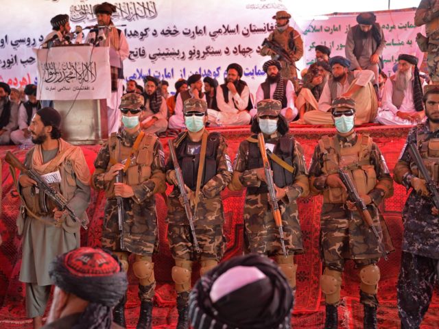 Taliban fighters stand guard as Taliban officials and commanders attend an open-air rally