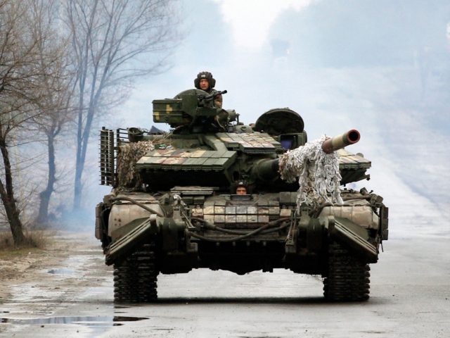 Ukrainian servicemen ride on tanks towards the front line with Russian forces in the Lugansk region of Ukraine on February 25, 2022. - Ukrainian forces fought off Russian troops in the capital Kyiv on the second day of a conflict that has claimed dozens of lives, as the EU approved …