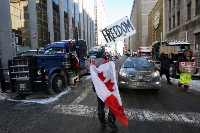 A person holds a sign reading "Freedom" as truckers and supporters continue to protest aga