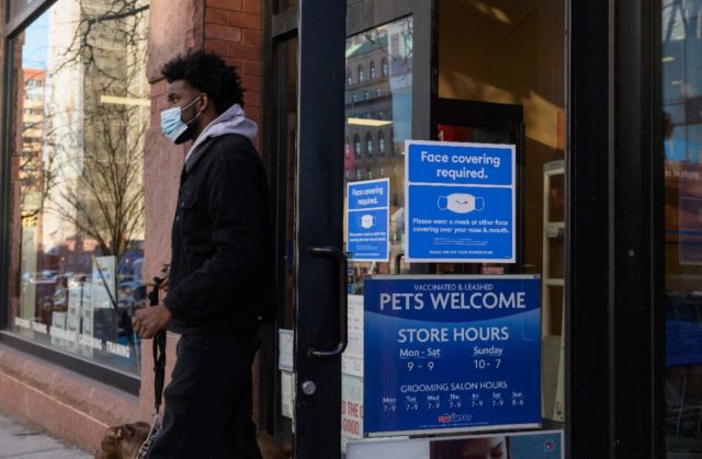 A person wearing a face mask leaves a store on January 26, 2022 in New York City; mask-wea