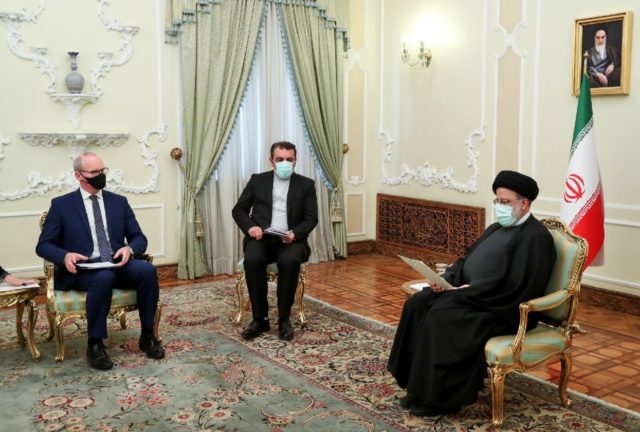 A handout picture provided by the Iranian President Ebrahim Raisi's office shows him (R) w