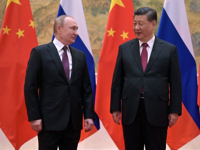TOPSHOT - Russian President Vladimir Putin (L) and Chinese President Xi Jinping pose durin