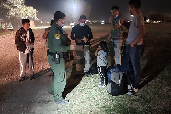 An Eagle Pass Border Patrol agents processes a group of migrants detained by Texas National Guard soldiers (Bob Price/Breitbart Texas)
