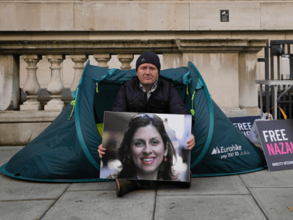 Richard Ratcliffe, husband of detained U.K. charity worker Nazanin Zaghari-Ratcliffe, holds a picture of his wife Nazanin as he sits opposite the Foreign Office in Westminster in London, Monday, Oct. 25, 2021. The husband of U.K. charity worker Zaghari-Ratcliffe, who has been detained for more than five years in Iran, …