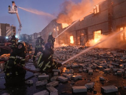Ukrainian firefighters extinguish a blaze at a warehouse after a bombing in Kyiv, Ukraine, Thursday, March 17, 2022. Russian forces destroyed a theater in Mariupol where hundreds of people were sheltering Wednesday and rained fire on other cities, Ukrainian authorities said, even as the two sides projected optimism over efforts …