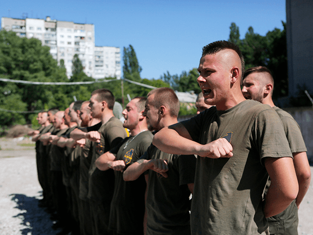 Volunteers from the Azov volunteer battalion read a prayer after a training session in Kie