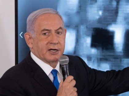 Israeli Prime Minister Benjamin Netanyahu gestures as he shows a slideshow during a briefi