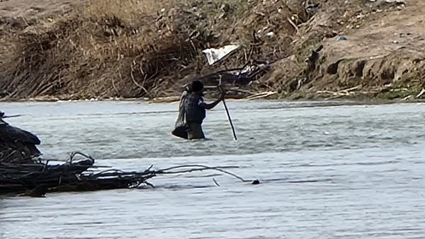 A border crosser regains his footing after being submerged by swiftly moving currents in the Rio Grande. (Bob Price/Breitbart Texas)