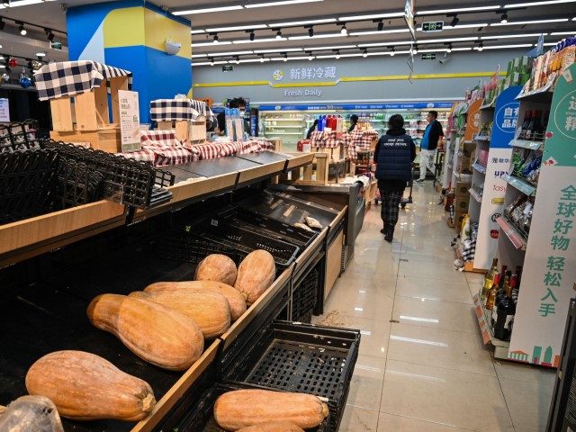 Shoppers rummage through empty shelves in a supermarket before a lockdown as a measure aga