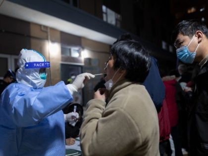 A woman gets her throat swabbed for a coronavirus test as part of mass COVID-19 testing in a residential community in Shanghai, Thursday, March 10, 2022. China is tackling a COVID-19 spike with selective lockdowns and other measures that appear to slightly ease its draconian "zero tolerance" strategy. (AP Photo)