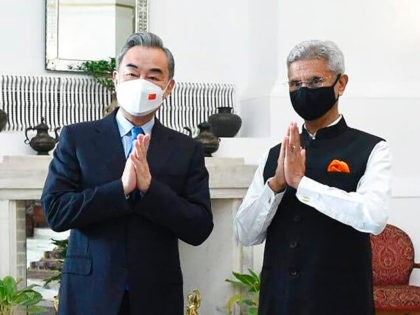 In this photo provided by Indian Foreign Minister S. Jaishankar's Twitter handle, Jaishankar and his Chinese counterpart Wang Yi greet the media before their meeting in New Delhi, India, Friday, March 25, 2022. Wang met with Jaishankar and the national security advisor on Friday as part of continuing efforts to …