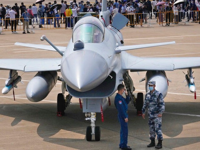 Chinese military personnel stand near a Chinese military's J-10C airplane during the 13th