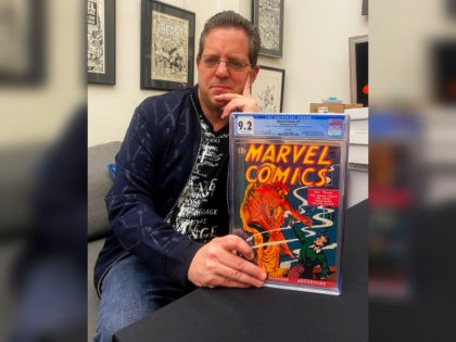 Stephen Fishler, co-owner and CEO of ComicConnect.com, poses for a photo holding up a copy of Marvel Comics #1, Friday, March 18, 2022, in New York. The prized copy of the first-ever Marvel comic book has fetched over $2.4 million in an online auction. (Michael Cohen via AP)