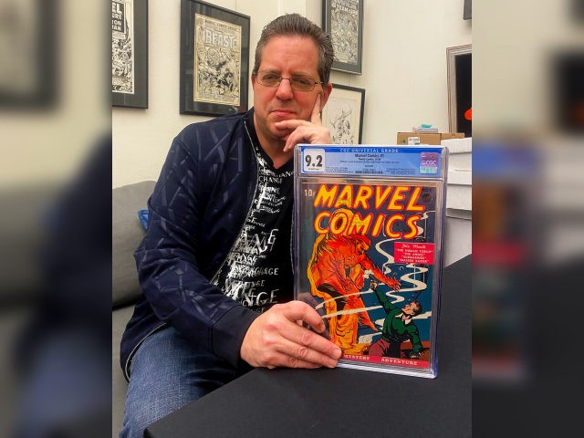 Stephen Fishler, co-owner and CEO of ComicConnect.com, poses for a photo holding up a copy