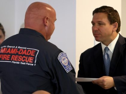 SURFSIDE, FLORIDA - AUGUST 10: Florida Gov. Ron DeSantis presents a check to a first responder during an event to give out bonuses to them held at the Grand Beach Hotel Surfside on August 10, 2021 in Surfside, Florida. DeSantis gave out some of the $1,000 checks that the Florida …