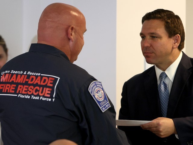 SURFSIDE, FLORIDA - AUGUST 10: Florida Gov. Ron DeSantis presents a check to a first responder during an event to give out bonuses to them held at the Grand Beach Hotel Surfside on August 10, 2021 in Surfside, Florida. DeSantis gave out some of the $1,000 checks that the Florida state budget passed for both first responders and teachers across the state.