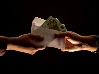 Male giving person envelope with euros, bribery and corruption concept, closeup