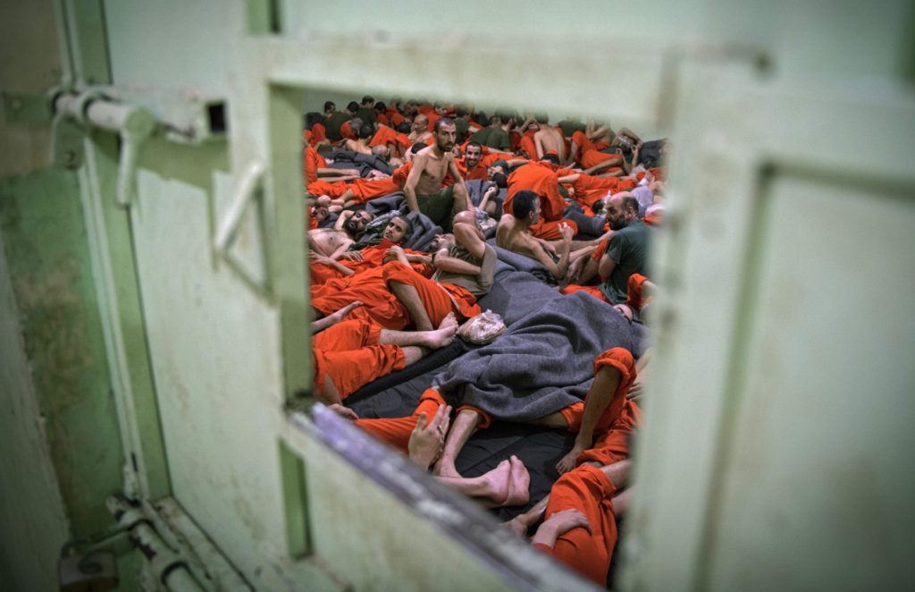 TOPSHOT - Men, suspected of being affiliated with the Islamic State (IS) group, gather in a prison cell in the northeastern Syrian city of Hasakeh on October 26, 2019. - Kurdish sources say around 12,000 IS fighters including Syrians, Iraqis as well as foreigners from 54 countries are being held in Kurdish-run prisons in northern Syria. (Photo by FADEL SENNA / AFP) (Photo by FADEL SENNA/AFP via Getty Images)