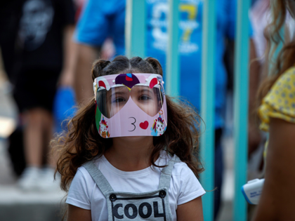 A pupil wearing a face mask arrives at a primary school on the first day of class of the new academic year in Athens, on September 14, 2020, amid the crisis linked with the covid-19 pandemic caused by the novel coronavirus. - Schools open on Monday amid concerns due to …