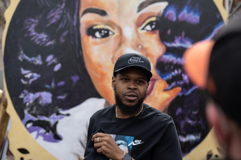 Kenneth Walker, boyfriend of Breonna Taylor, stands in front of a portrait of Taylor during a protest memorial for her in Jefferson Square Park on March 13, 2021 in Louisville, Kentucky. Today marks the one year anniversary since Taylor was killed in her apartment during a botched no-knock raid executed by LMPD. (Photo by Jon Cherry/Getty Images)