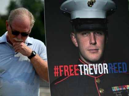 Joe Reed, the father of former US Marine Trevor Reed, stands next to a placard of his son outside the US Capitol in Washington, DC, on July 29, 2021, during a press conference. - The conference was held to call out the prison conditions and push for a new congressional …