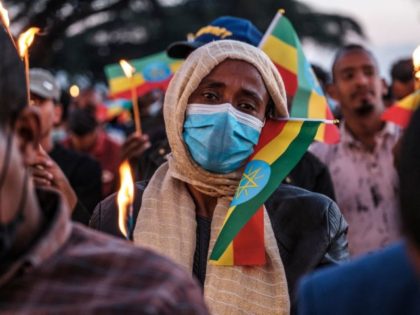 A woman holds a candle during a memorial service for the victims of the Tigray conflict organized by the city administration, in Addis Ababa, Ethiopia, on November 3, 2021.