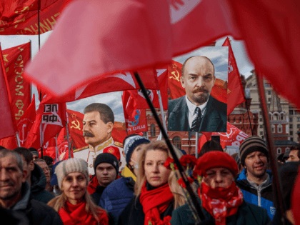 TOPSHOT - Russian Communist party activists and supporters carry portraits of Soviet founder Vladimir Lenin (R) and Soviet dictator Josef Stalin (L) as they attend a flowers-laying ceremony at the Lenin's Mausoleum on Red Square in downtown Moscow on November 7, 2021, marking the 104th anniversary of the Bolshevik Revolution …