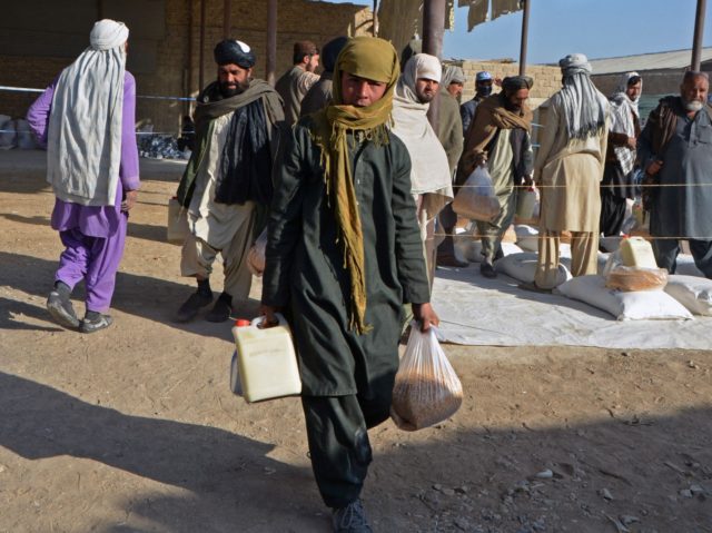 An Afghan boy carries food packets being distributed by the members of World Food Programme (WFP) to the needy families in Kandahar on December 23, 2021. (Photo by Javed TANVEER / AFP) (Photo by JAVED TANVEER/AFP via Getty Images)