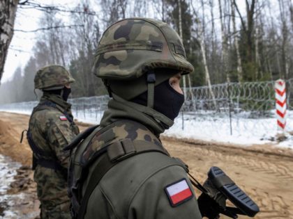 Polish soldiers are seen during the construction of a border wall along the Polish-Belarus border in Tolcze, Sokolka County, Podlaskie Voivodeship, in north-eastern Poland on January 27, 2022. - Polish contractors began work on a 353-million euro wall along the Belarus border aimed at deterring migrant crossings following a crisis …