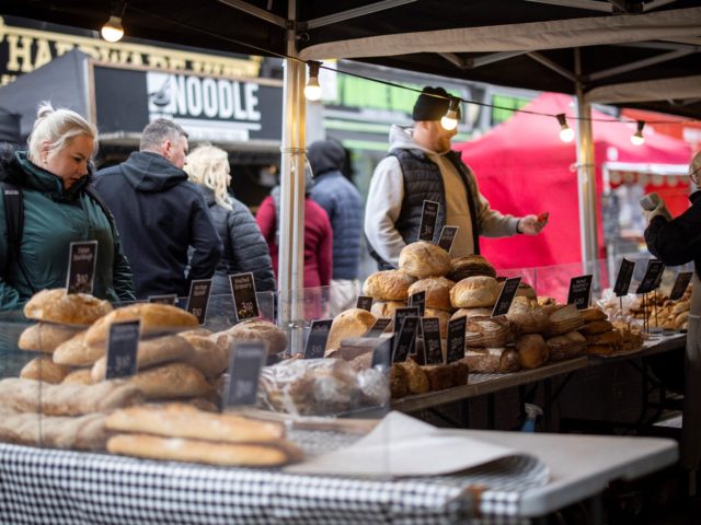 Customers shop for bread on a market stall in Walthamstow, east London on February 13, 202