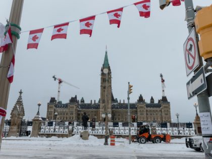 City employees clean up Wellington Street in front of Parliament Hill, previously occupied by the Freedom Convoy, in Ottawa, Ontario, Canada, on February 20, 2022. - The last big rigs were being towed Sunday out of Canada's capital, where the streets were quiet for the first time in three weeks …