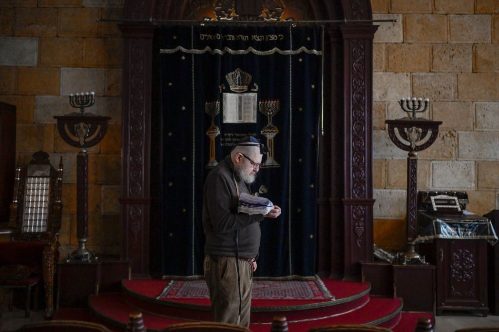 A Jewish faithful prays in the Chabad Synagogue in Odessa on March 9, 2022, 14 days after Russia launched a military invasion on Ukraine. - Forced yet again into exile, as so many times in their tormented history, Jews are leaving in droves from the Ukrainian city of Odessa, threatening the last traces of a once-vibrant culture. The Black Sea port, a place steeped in Jewish history, now sees many joining the throngs as they pack buses and trains heading for Moldova or Romania. Some will go on to Germany, the United States, or Israel. Many are old, knowing that they may well never return. (Photo by BULENT KILIC / AFP) (Photo by BULENT KILIC/AFP via Getty Images)