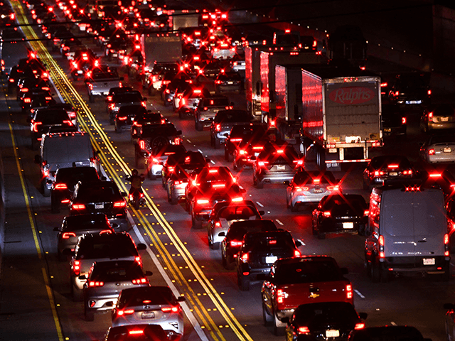 A motorcyclist drives between cars, trucks, and sport utility vehicles (SUVs) on the 405 Freeway during rush hour traffic as oil and gasoline fuel prices experienced an increase on March 10, 2022 in Los Angeles, California. - US consumer prices hit a new 40-year high last month as the world's largest economy continued to be battered by a surge of inflation, which the fallout from Russia's invasion of Ukraine is expected (Photo by Patrick T. FALLON / AFP) (Photo by PATRICK T. FALLON/AFP via Getty Images)