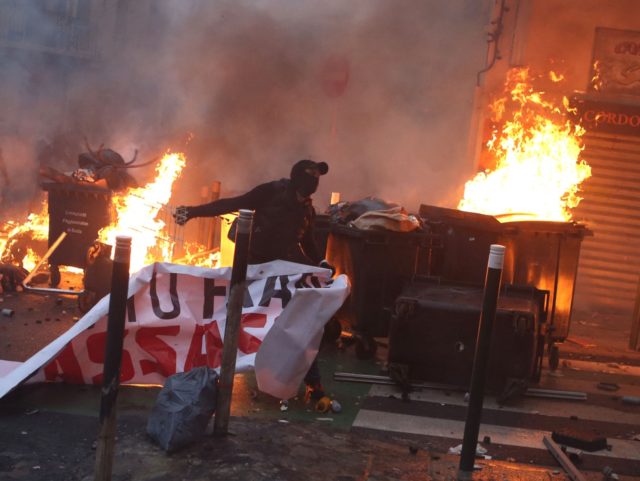 A protester clashes with police in Bastia on March 13, 2022, following a rally in hommage