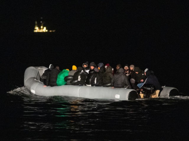 Migrants sits in a dinghy illegally crossing the English Channel from France to Britain on