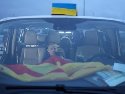 TOPSHOT - A Ukrainian boy, one of the refugees carried by the convoy of Spanish taxi drivers, looks on as he sits in a taxi, during a stop in Burgos, on March 16, 2022. - Spanish taxi drivers organised a caravan from Madrid to Poland to transport Ukrainian families fleeing …