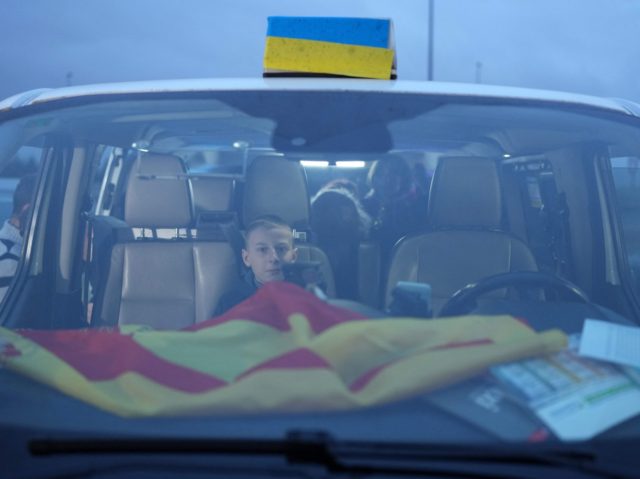 TOPSHOT - A Ukrainian boy, one of the refugees carried by the convoy of Spanish taxi drive