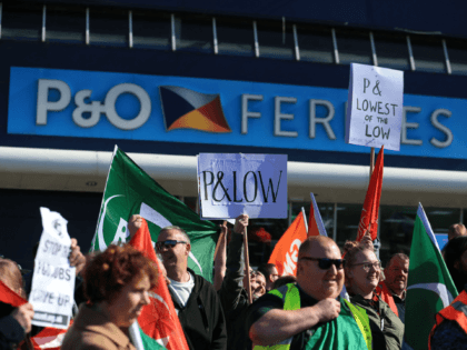 People hold placards during a demonstration against the sacking of 800 P&O workers, outside the P&O offices at the Port of Hull, eastern England, on March 18, 2022. - P&O Ferries, which sails daily between Britain and France, on Thursday axed 800 UK crew with immediate effect and suspended services …