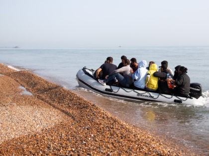 DEAL, ENGLAND - SEPTEMBER 14: A fisherman watches as migrants land on Deal beach after crossing the English channel from France in a dinghy on September 14, 2020 in Deal, England. More than 1,468 migrants, some of them children, crossed the English Channel by small boat in August, despite a …